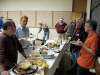 Discussion around the buffet table at our annual holiday party